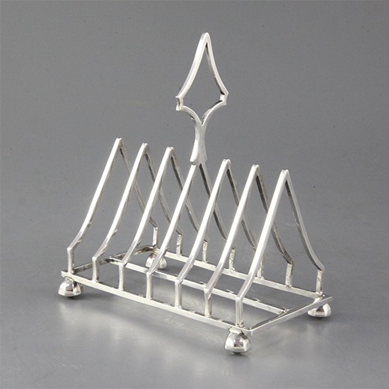 An Edwardian silver triangular seven bar toastrack, on octagonal bun feet, Mappin & Webb, Sheffield, 1901, 9 oz.
